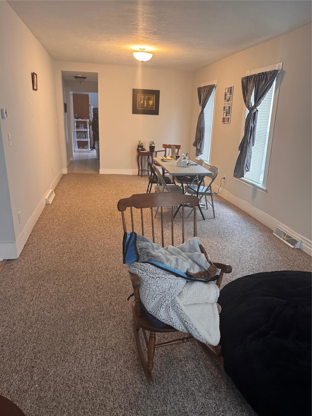 carpeted dining room with visible vents and baseboards