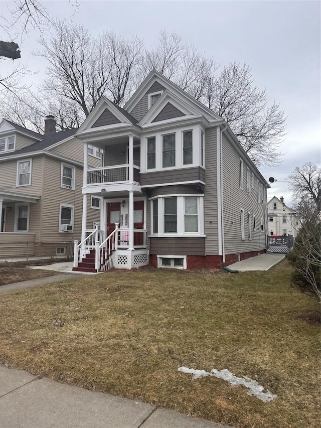 view of front of property with a balcony and a front lawn