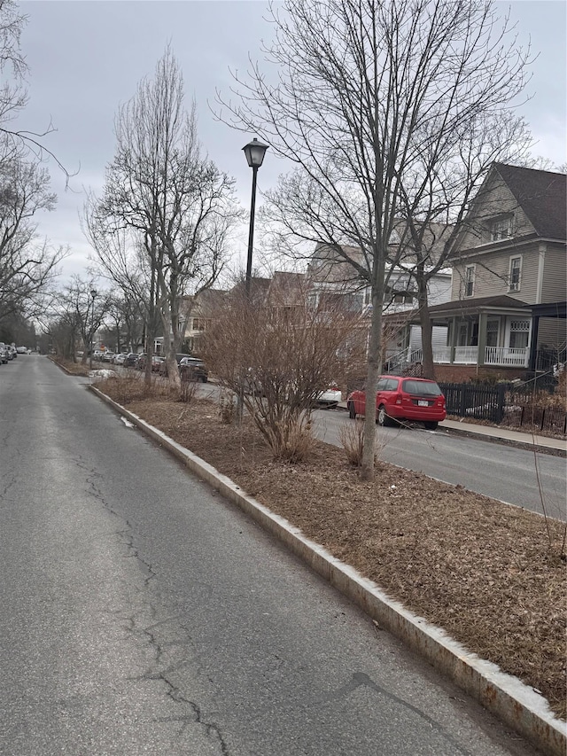 view of street with curbs, a residential view, and street lighting