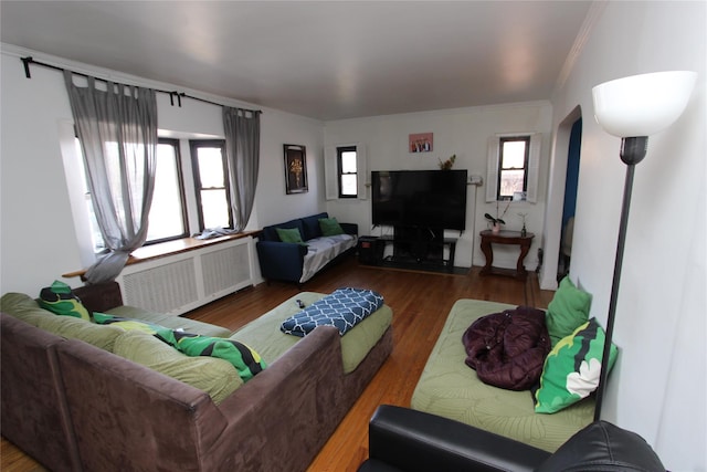 living room with wood finished floors, radiator heating unit, and ornamental molding