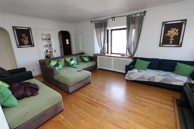 living room with light wood-style flooring, radiator heating unit, and arched walkways