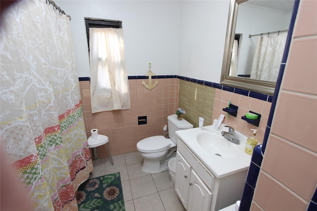 full bath with vanity, a wainscoted wall, tile patterned floors, toilet, and tile walls