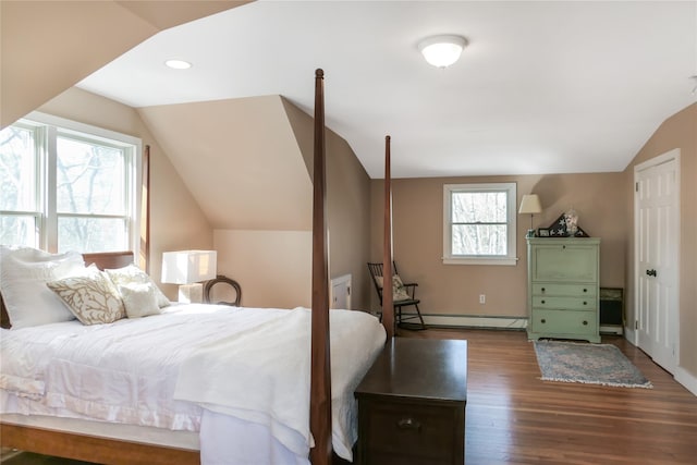 bedroom with a baseboard heating unit, vaulted ceiling, and wood finished floors