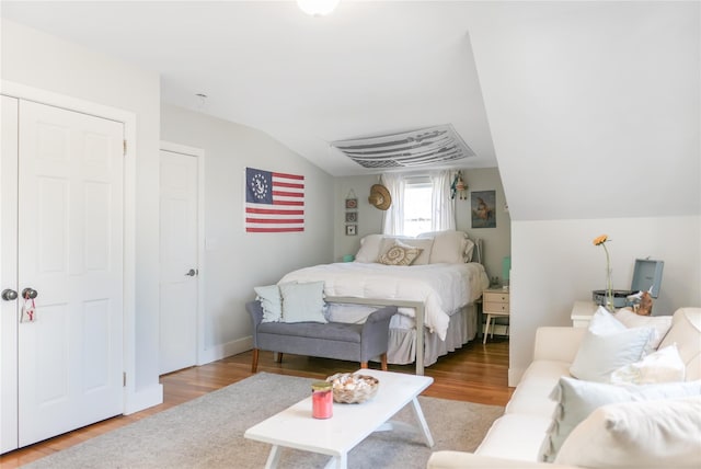 bedroom featuring lofted ceiling and wood finished floors