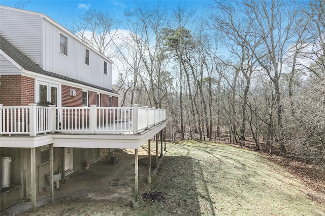 view of yard with a deck, a carport, and dirt driveway