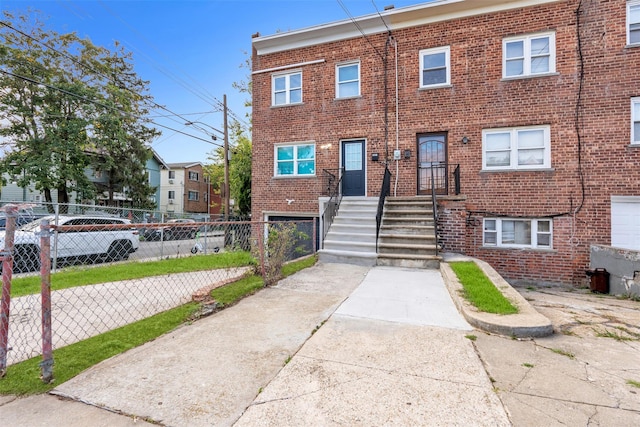 view of property with fence and brick siding