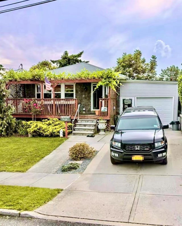 ranch-style home featuring a front lawn, a porch, concrete driveway, and an attached garage