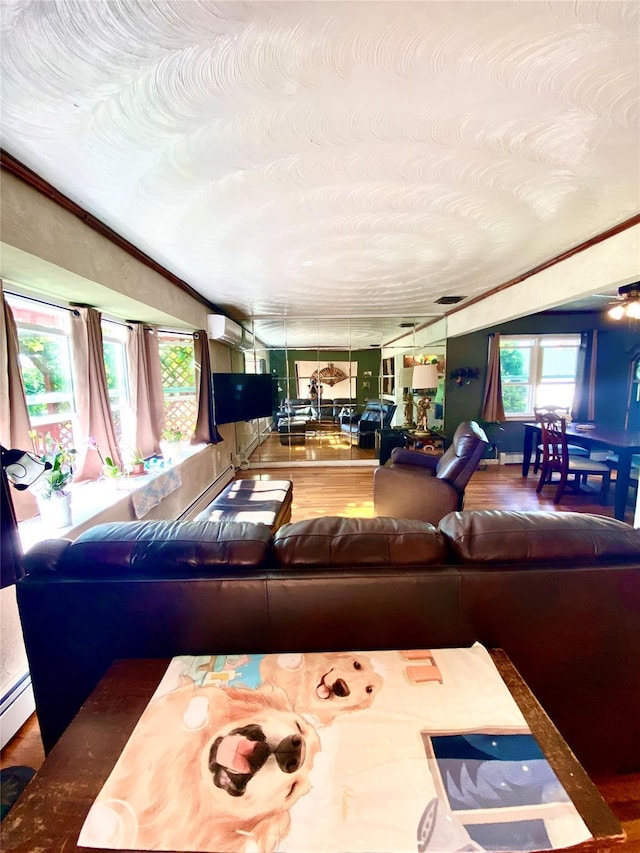 living area featuring ornamental molding, wood finished floors, visible vents, and a wall mounted AC