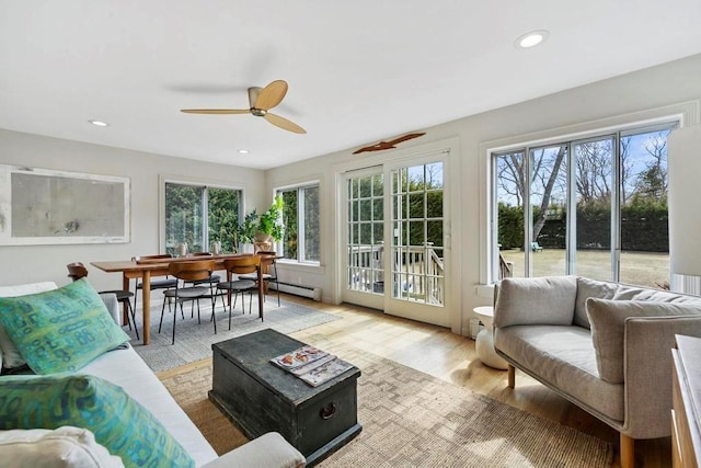 living room featuring recessed lighting, a baseboard heating unit, light wood-style floors, and ceiling fan