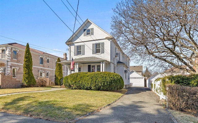 view of front of house featuring a front yard, a detached garage, and an outdoor structure