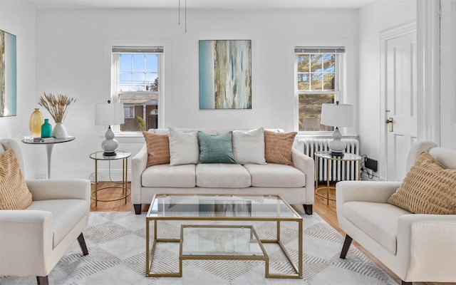 living room with a wealth of natural light, radiator heating unit, and light wood finished floors