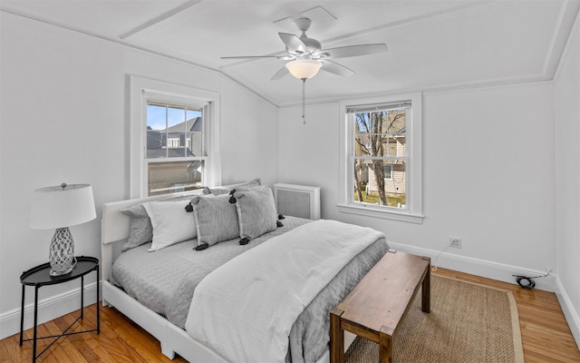 bedroom with ceiling fan, lofted ceiling, baseboards, and wood finished floors