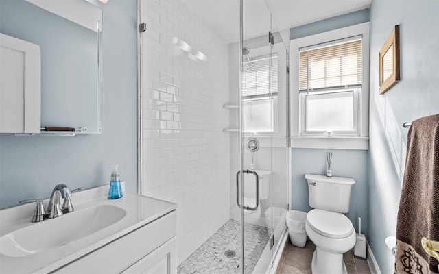 bathroom with vanity, a shower stall, and toilet