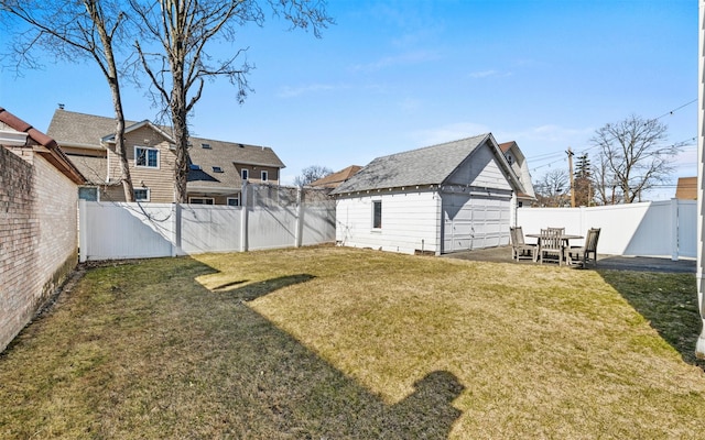 view of yard featuring an outbuilding, a detached garage, and a fenced backyard