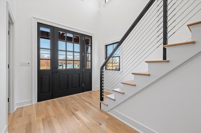 entrance foyer featuring stairs, wood finished floors, and baseboards