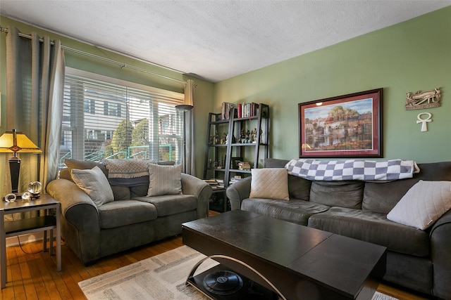 living area with a textured ceiling and hardwood / wood-style floors