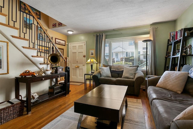 living room featuring stairway, wood finished floors, and a textured ceiling