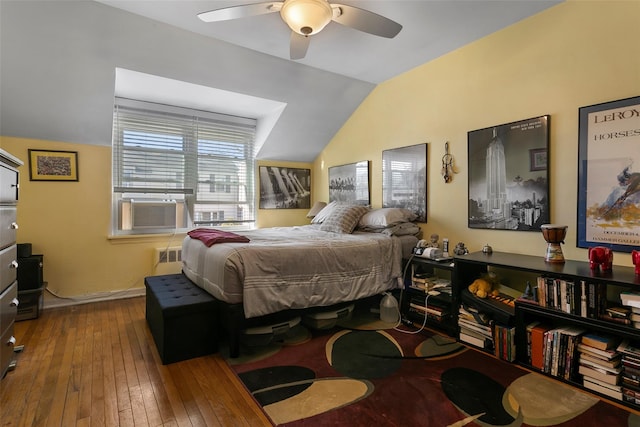 bedroom with hardwood / wood-style floors, cooling unit, a ceiling fan, baseboards, and vaulted ceiling