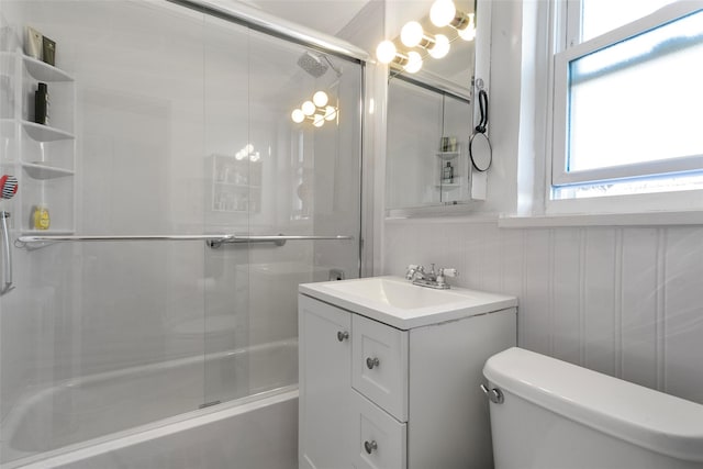 bathroom featuring vanity, toilet, and bath / shower combo with glass door