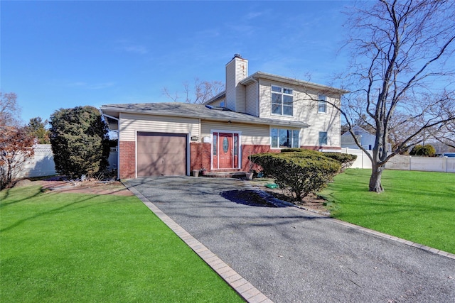 view of front facade featuring driveway, a front lawn, a garage, brick siding, and a chimney