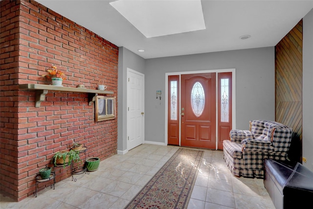 entrance foyer featuring light tile patterned flooring, baseboards, brick wall, and an accent wall