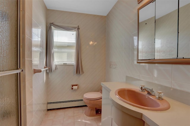 bathroom with vanity, tile patterned flooring, a baseboard heating unit, tile walls, and toilet