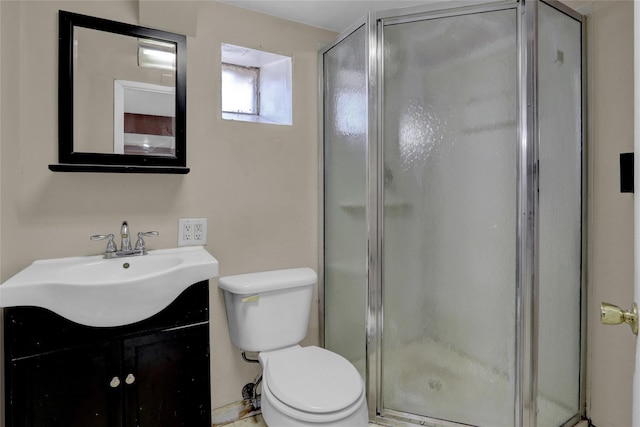 bathroom featuring vanity, a shower stall, and toilet