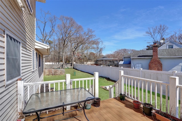 deck with a fenced backyard, outdoor dining space, and a yard