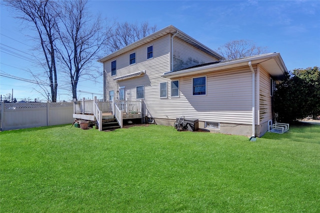 back of house with a deck, a lawn, and fence