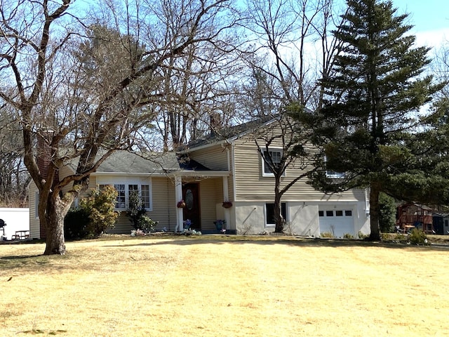 tri-level home with a garage and a front lawn