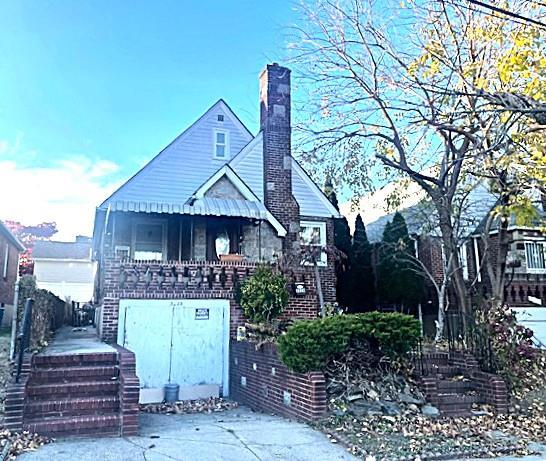 view of front facade featuring a chimney and stairs