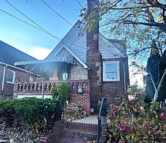 view of side of home with brick siding and a chimney