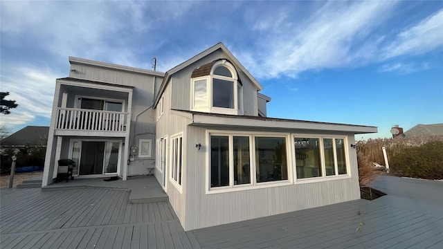 back of property with a wooden deck and a balcony