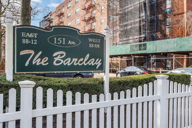 community / neighborhood sign featuring fence