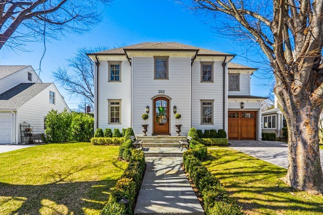 view of front facade featuring a garage, driveway, and a front yard