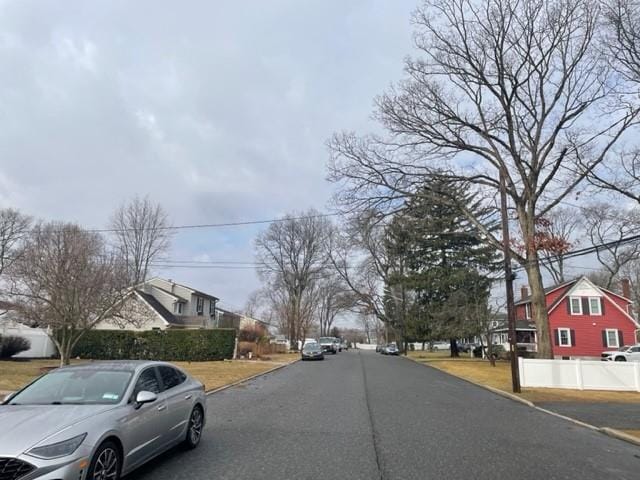 view of road with a residential view and curbs