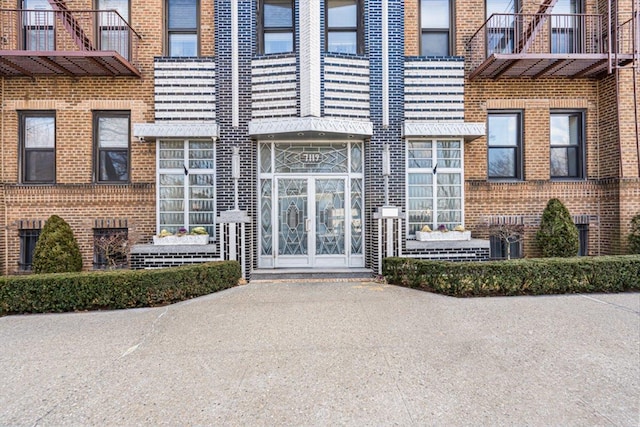 view of exterior entry featuring brick siding