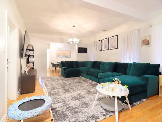 living room with an inviting chandelier and light wood-style flooring