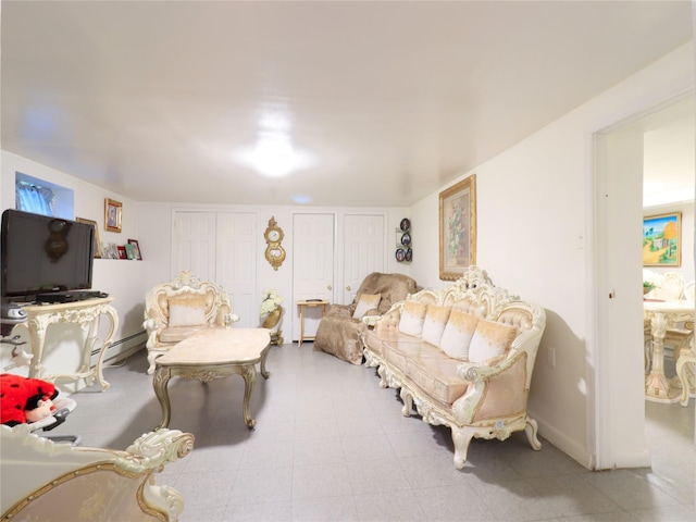 bedroom featuring two closets, a baseboard heating unit, and baseboards