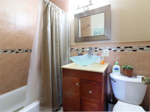 full bathroom featuring shower / bath combo with shower curtain, toilet, tile walls, and vanity