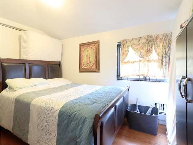 bedroom featuring a closet, lofted ceiling, and wood finished floors