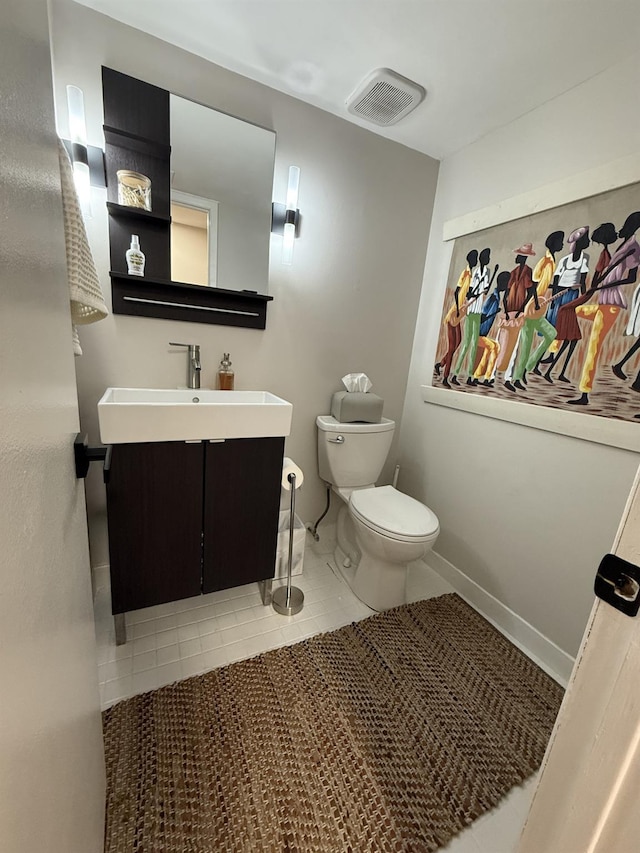 half bathroom with visible vents, toilet, tile patterned flooring, baseboards, and vanity