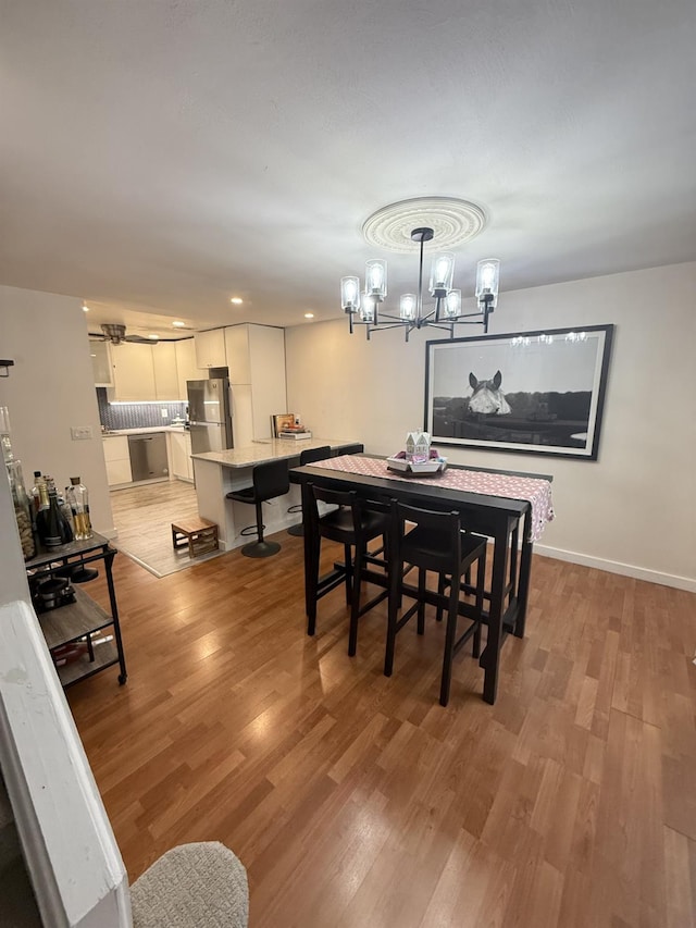 dining area featuring recessed lighting, baseboards, light wood finished floors, and a chandelier