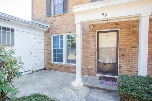 doorway to property featuring brick siding