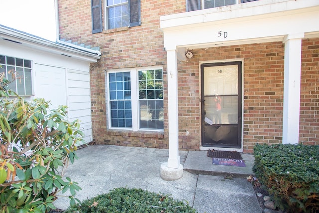 property entrance featuring brick siding