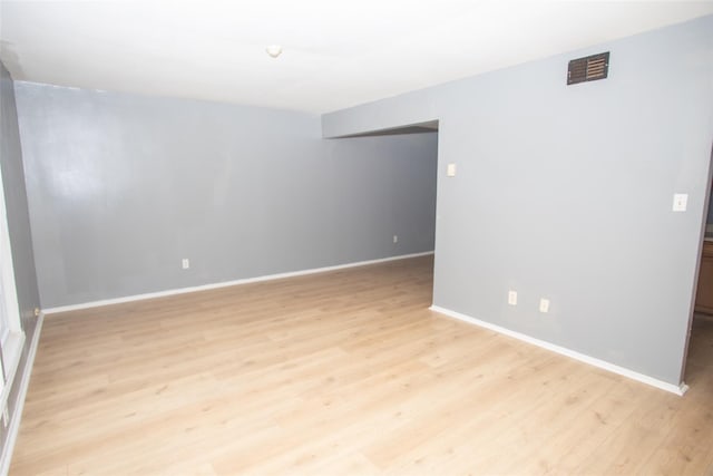 empty room with light wood-style flooring, baseboards, and visible vents