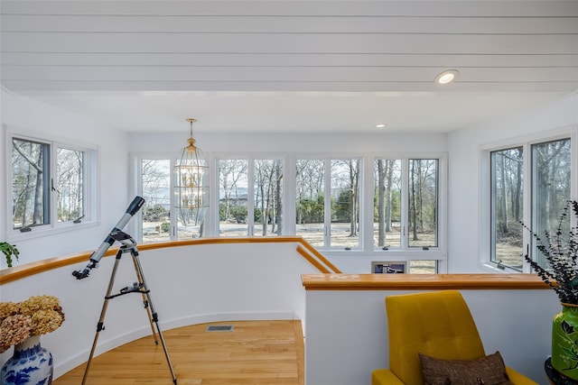 sunroom / solarium featuring a wealth of natural light, visible vents, and a chandelier