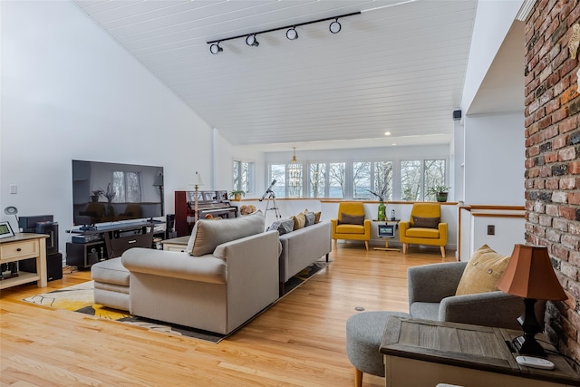 living area with light wood-style floors and high vaulted ceiling