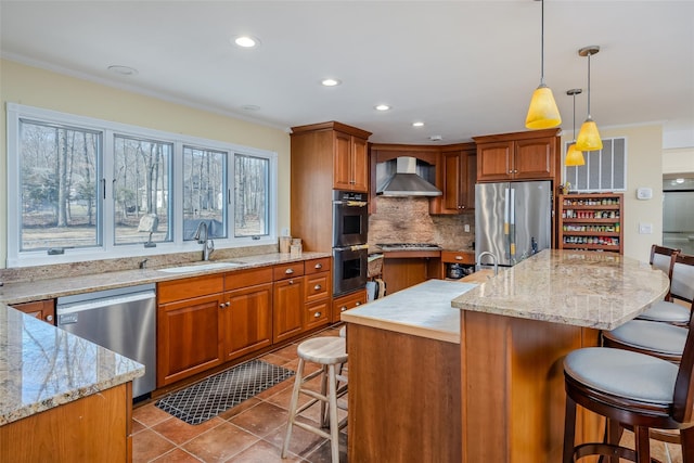 kitchen with a kitchen bar, a sink, appliances with stainless steel finishes, wall chimney exhaust hood, and tile patterned flooring