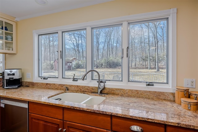 kitchen with ornamental molding, a sink, glass insert cabinets, light stone countertops, and dishwasher